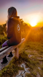 Dusk to Dawn hoodie being worn in front of a sunset